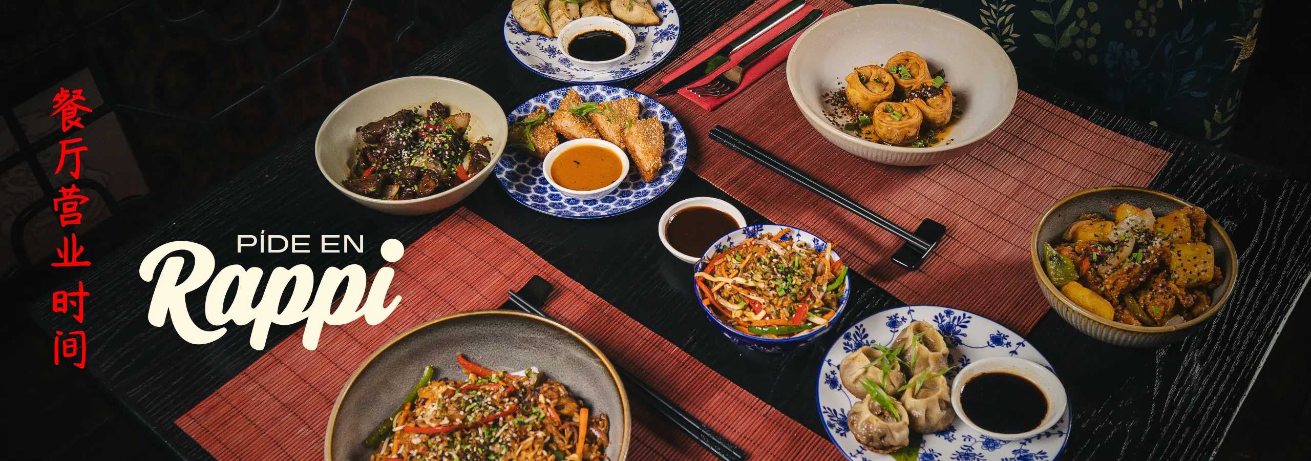 banner_web rappi 2560×900 Assorted Asian dishes laid out on a dark table, with red Chinese characters on the left and 'Pide en Rappi' promotional text.