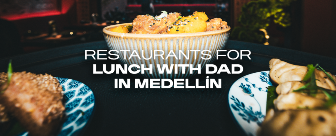 Banner image of a bowl of fried chicken and potatoes on a table with city lights in the background; text reads 'Restaurants for lunch with dad in Medellín'.