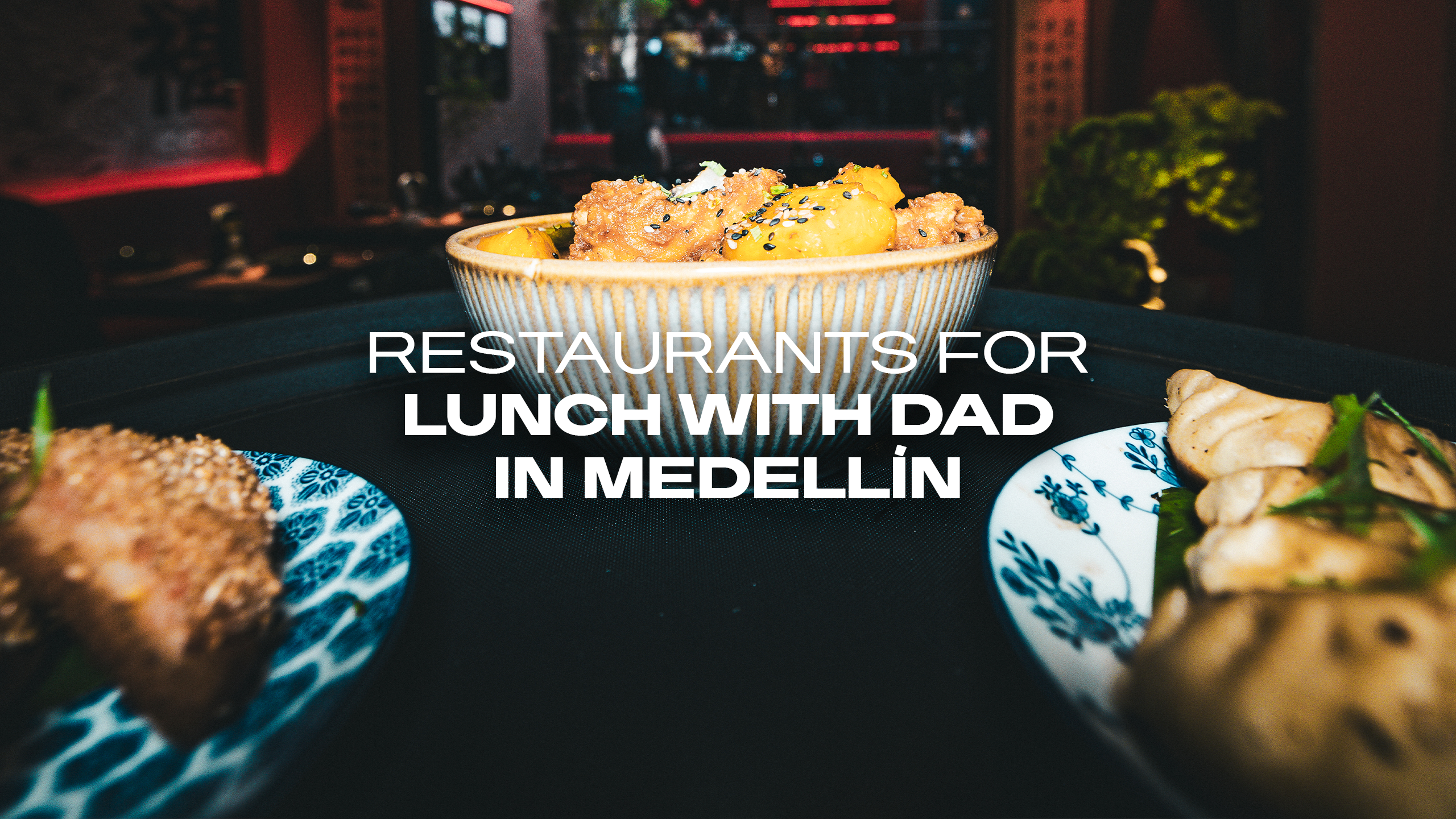 Banner image of a bowl of fried chicken and potatoes on a table with city lights in the background; text reads 'Restaurants for lunch with dad in Medellín'.